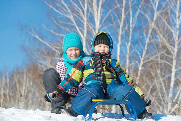 Two cute kids riding sled — Stock Photo, Image