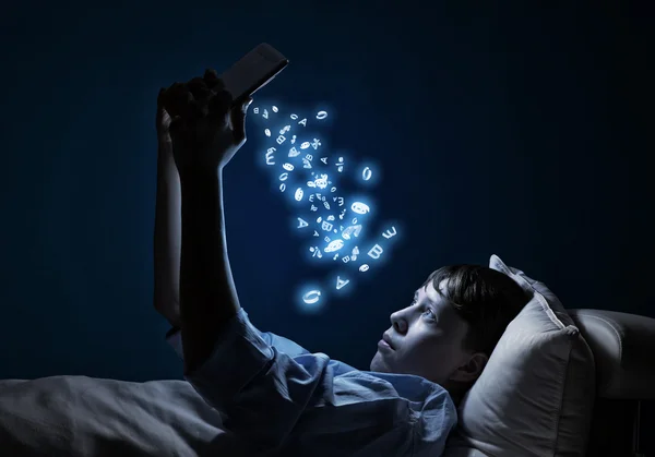 Adolescente leyendo en la cama — Foto de Stock