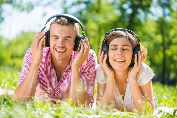 Pareja en parque escuchando música — Foto de Stock