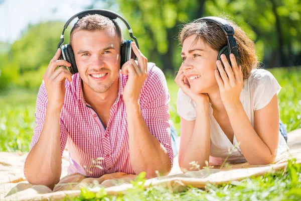 Koppel in park luisteren muziek — Stockfoto