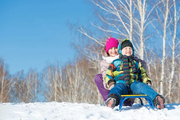 Two cute kids riding sled — Stock Photo, Image