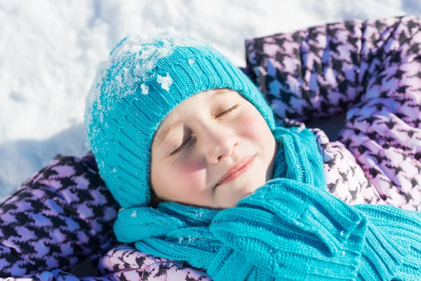 Menina deitada na neve — Fotografia de Stock