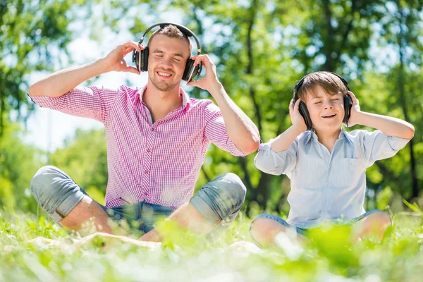 Père et fils appréciant la musique — Photo