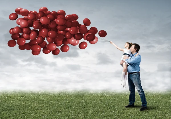 Glückliche Familie mit Luftballons — Stockfoto