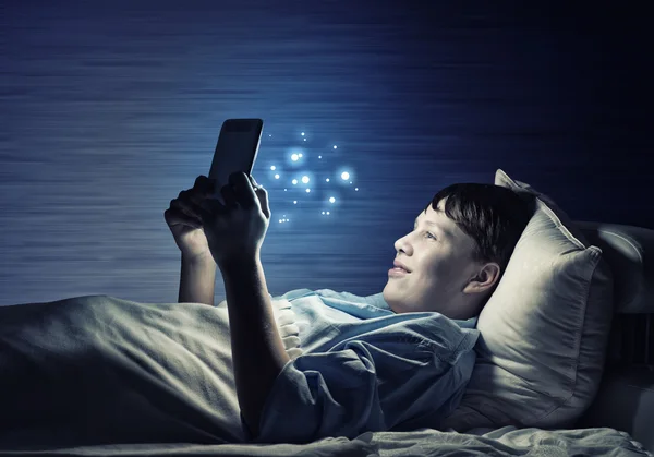 Teenager čtení v posteli — Stock fotografie