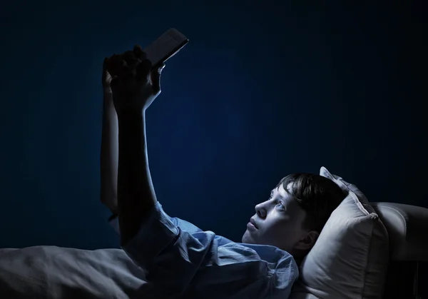 Teenager liest im Bett — Stockfoto