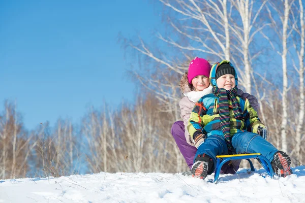 Two cute kids riding sled — Stock Photo, Image