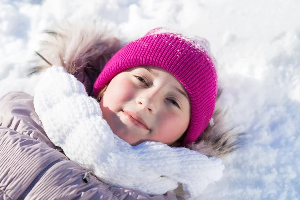 Meisje liggend op sneeuw — Stockfoto