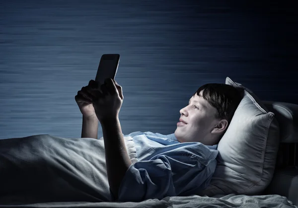 Teenager liest im Bett — Stockfoto