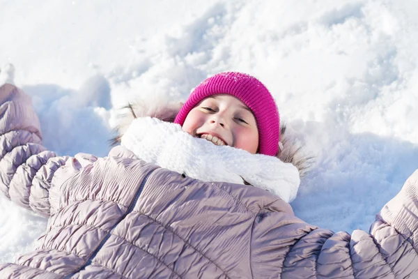Meisje liggend op sneeuw — Stockfoto