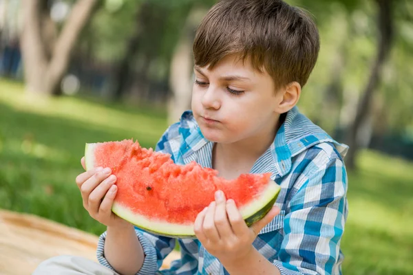 Rapaz bonito comendo melancia — Fotografia de Stock