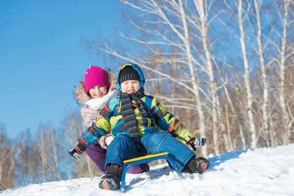 Two cute kids riding sled — Stock Photo, Image