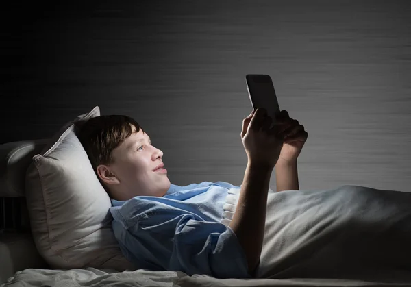 Nastolatek czytania w łóżku — Zdjęcie stockowe