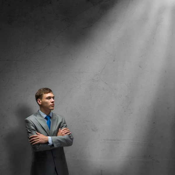 Businessman standing in rays of light — Stock Photo, Image