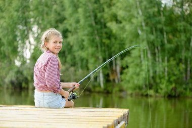 çubuk ile iskele üzerinde oturan kız
