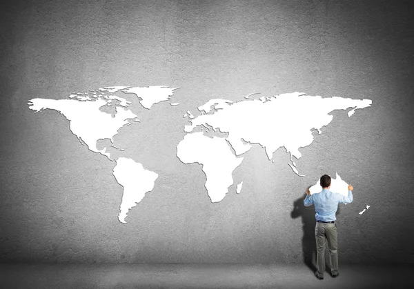 Empresário colocando continentes na parede — Fotografia de Stock