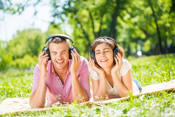 Pareja en parque escuchando música — Foto de Stock