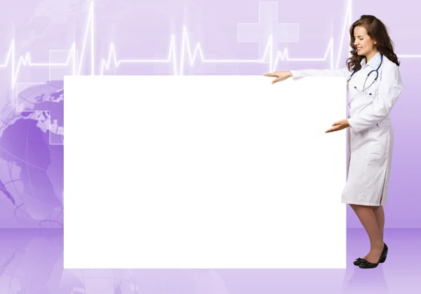 Young woman doctor standing near a blank banner — Stock Photo, Image