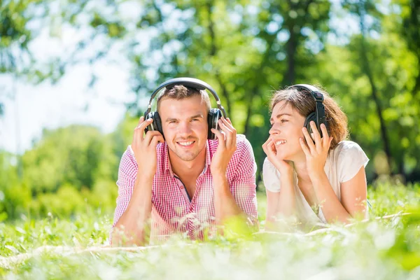 Couple in park listening music — Stock Photo, Image