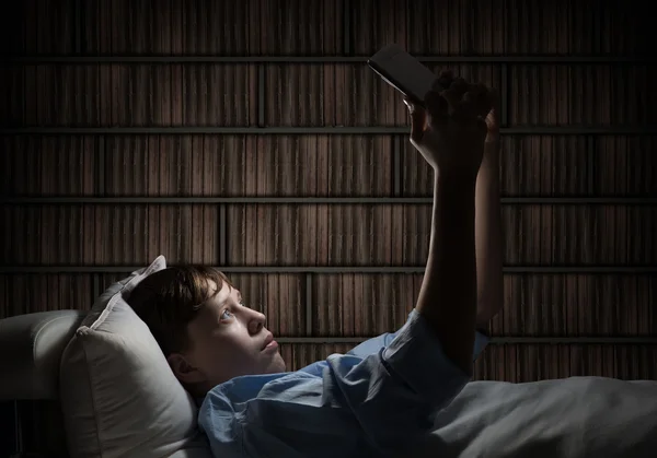 Teenager Reading in bed — Stock Photo, Image