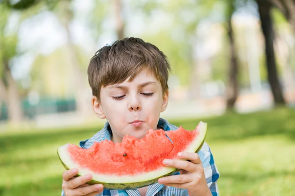 Lindo chico comiendo jugosa sandía — Foto de Stock