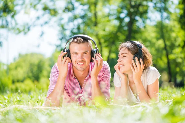 Couple in park listening music — Stock Photo, Image