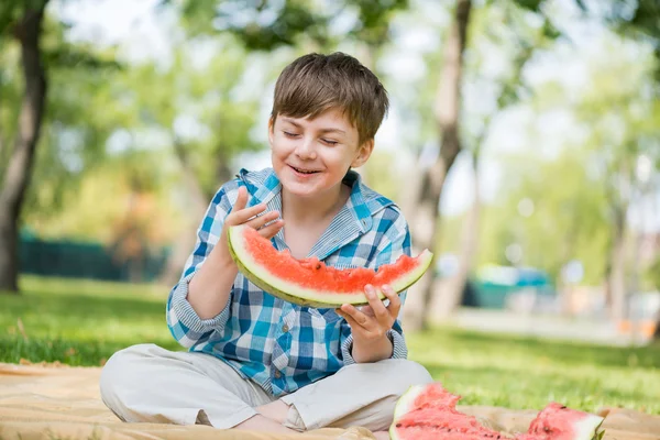 Söpö poika syö mehukas vesimeloni — kuvapankkivalokuva