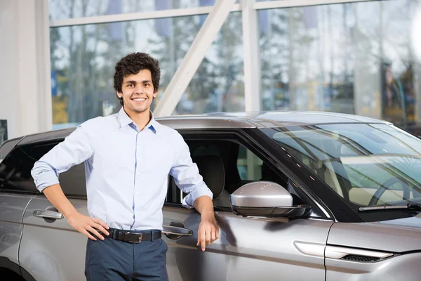 Joven hombre guapo en la sala de exposición — Foto de Stock