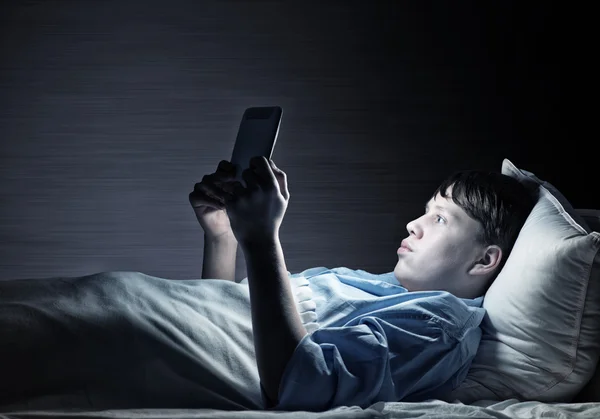 Teenager Reading in bed — Stock Photo, Image