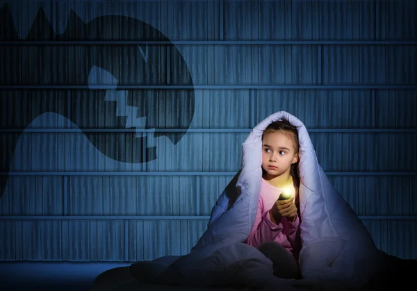 Girl under the covers with a flashlight — Stock Photo, Image