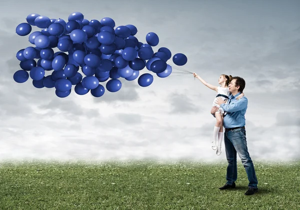 Glückliche Familie mit Luftballons — Stockfoto