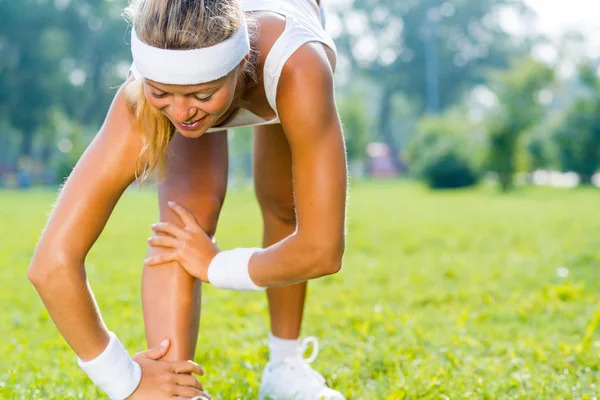 Junges Fitness-Mädchen dehnt sich im Park — Stockfoto