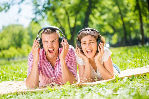 Couple in park listening music — Stock Photo, Image