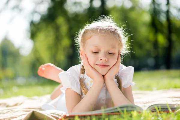 Mädchen im Park liest Buch — Stockfoto