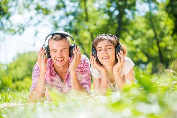 Couple in park listening music — Stock Photo, Image