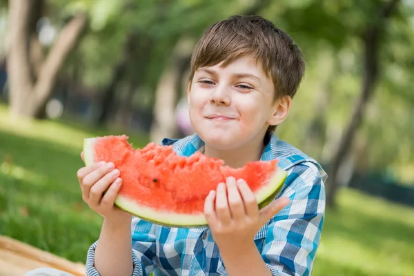 Rapaz bonito comendo melancia suculenta — Fotografia de Stock