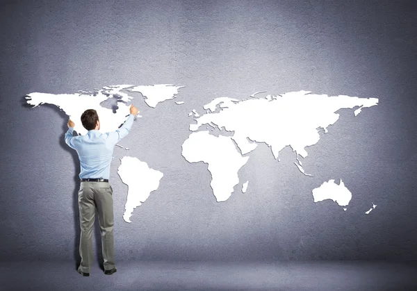 Businessman placing continents on wall — Stock Photo, Image