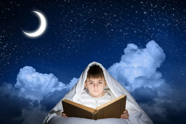 ベッド本を読む少年 — ストック写真