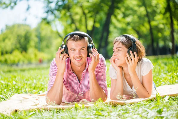 Pareja en parque escuchando música — Foto de Stock