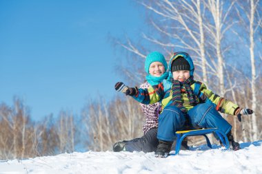 İki sevimli çocuk kızak sürme