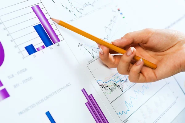 Hand pointing on financial charts — Stock Photo, Image