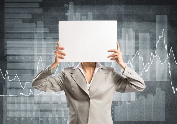 Businesswoman hiding her face behind paper — Stock Photo, Image