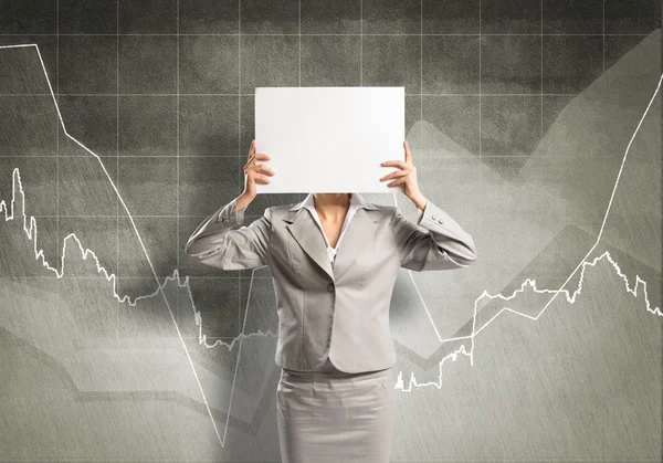 Businesswoman hiding her face behind paper — Stock Photo, Image