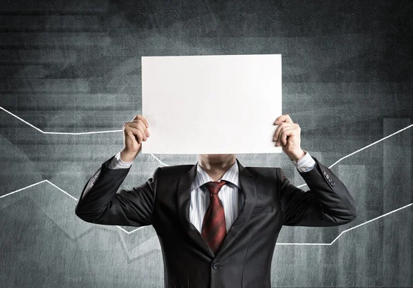 Businessman hiding his face behind paper — Stock Photo, Image