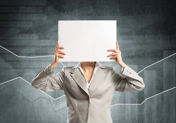 Businesswoman hiding her face behind paper — Stock Photo, Image