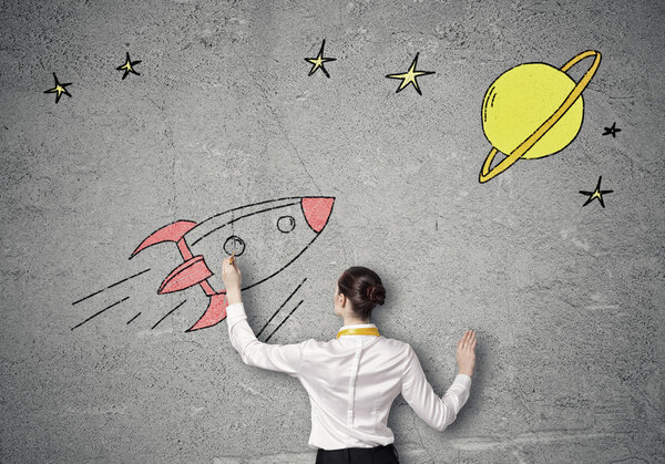 Businesswoman drawing rocket