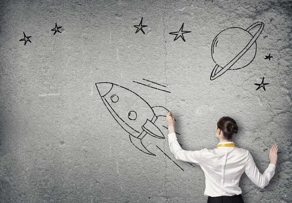 Businesswoman drawing rocket — Stock Photo, Image