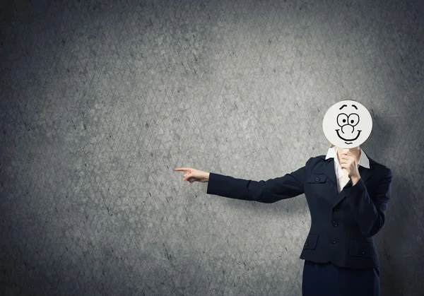 Businesswoman hiding face behind mask — Stock Photo, Image