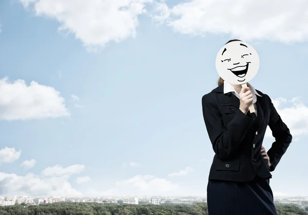 Mujer de negocios escondiendo la cara detrás de la máscara — Foto de Stock