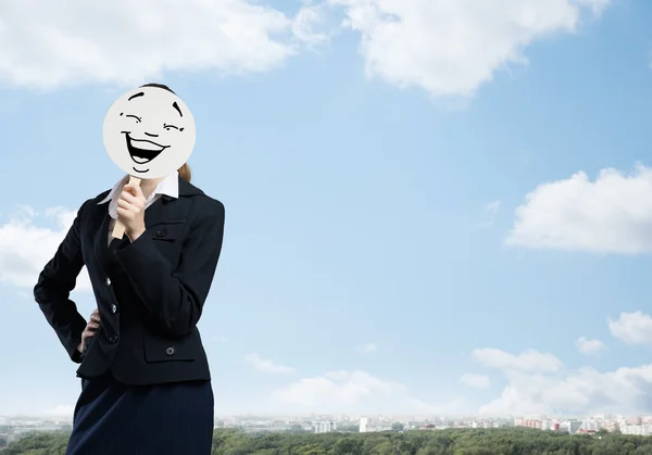 Mujer de negocios escondiendo la cara detrás de la máscara — Foto de Stock